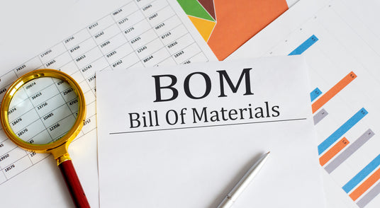 Bill of materials document with a pen, magnifying glass and charts in the background.